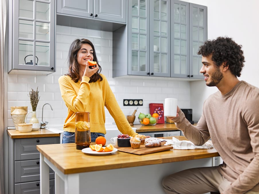 Un couple prenant son petit-déjeuner dans une cuisine lumineuse et entièrement équipée